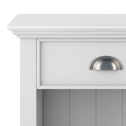 Close-up of the top section of the Acadian - Bedside Table, Handcrafted: a white wooden cabinet with a single drawer featuring a silver cup pull handle and an open shelf below.