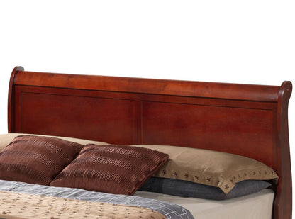 A close-up view of the Louis Phillipe - Storage Bed’s dark wooden sleigh headboard with brown and beige pillows and bedding.