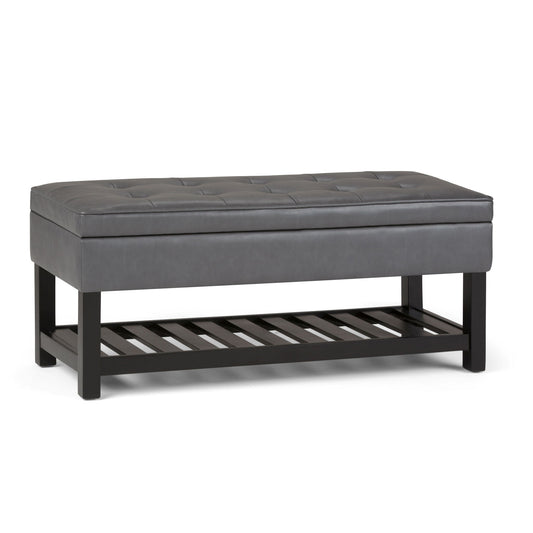 The Cosmopolitan - Storage Ottoman Bench With Open Bottom features a rectangular gray tufted padded seat, black wooden legs, and a slatted storage shelf, shown against a white background.
