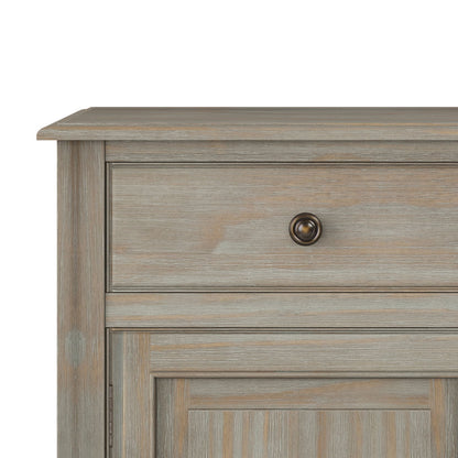A close-up of the Connaught Entryway Storage Cabinet in distressed gray, showing its wood texture, a drawer with a round metal knob, and a panel beneath the drawer.