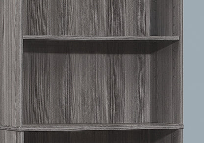 A close-up of the 6-tier Bookshelf Bookcase for office use, featuring a grey woodgrain finish, adjustable shelf holes, and a transitional design against a light blue background.