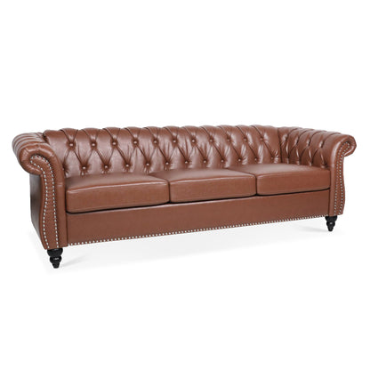 The Rolled Arm Chesterfield 3 Seater Sofa features brown leather upholstery, a tufted back, rolled arms, nailhead trim, three seat cushions, and black wooden legs.