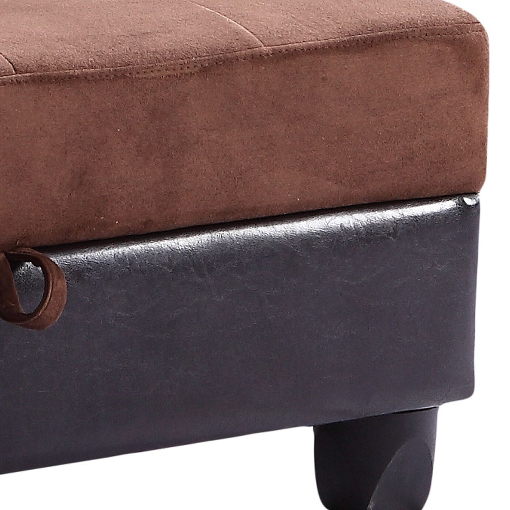 Close-up of the corner of a brown cushion atop the Stylish Storage Contemporary Ottoman, featuring black faux leather upholstery, short black legs, and a small fabric loop on the left side.