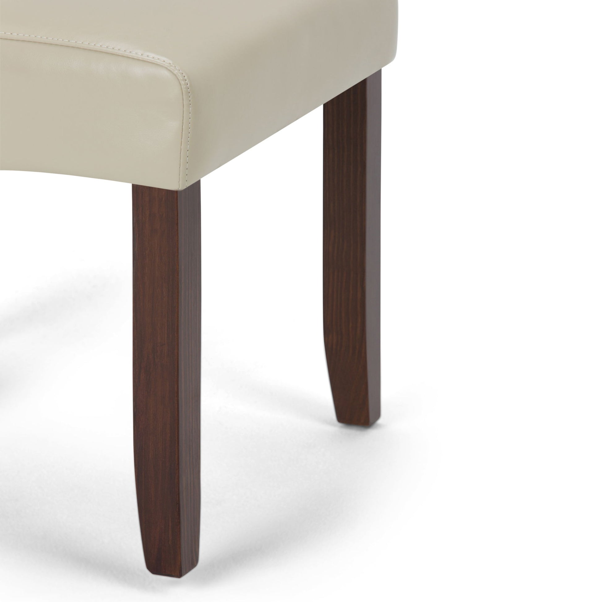 Close-up of the Cosmopolitan - Deluxe Tufted Parson Upholstered Chair (Set of 2), featuring a light beige upholstered seat and two dark brown wooden legs against a white background.