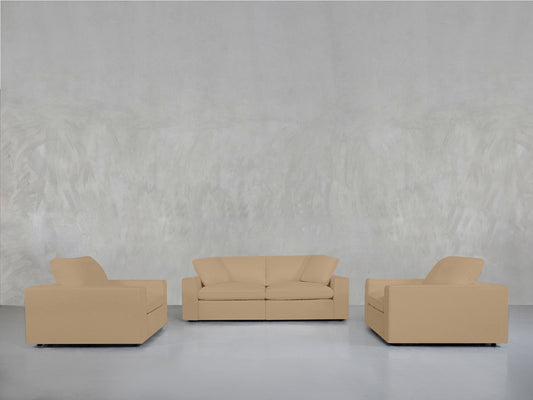 The 2-1-1 Sofa & Armchair Set, featuring a beige upholstered two-seater and two matching armchairs, is arranged in a minimalist layout against a light gray textured wall.
