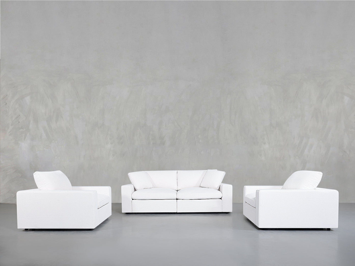 Minimalist scene featuring the 2-1-1 Sofa & Armchair Set with a white sofa and two matching white armchairs in a U-shape against a plain light gray wall and floor.