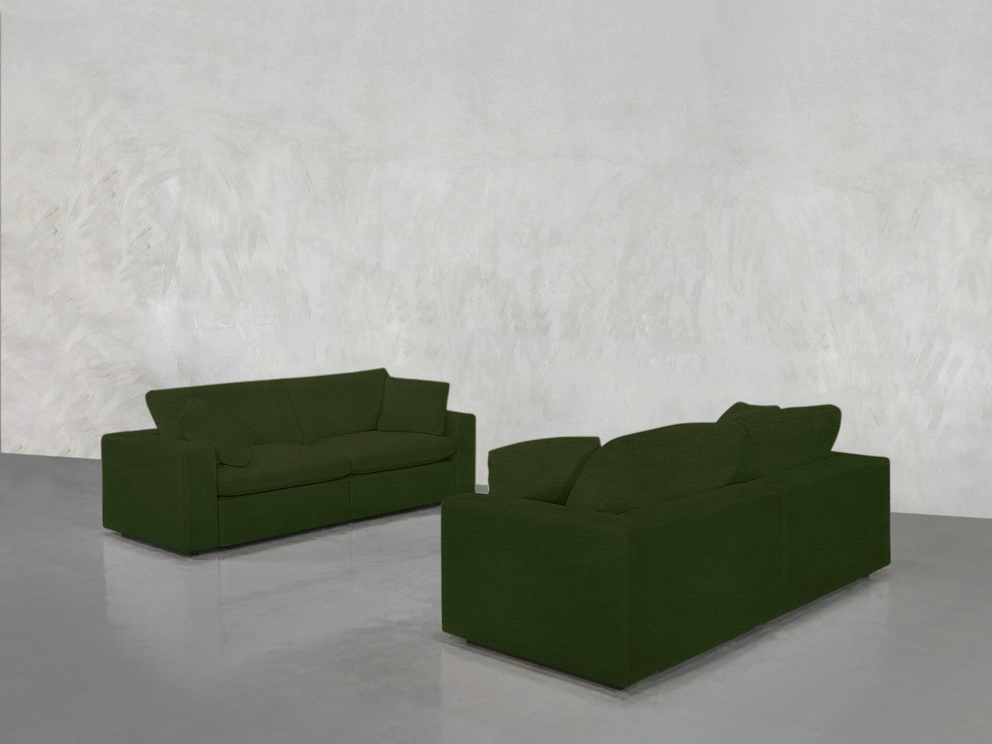 Two 2-2 Sofa Set pieces in dark green are placed facing each other in a minimalistic room with light gray walls and a glossy gray floor.