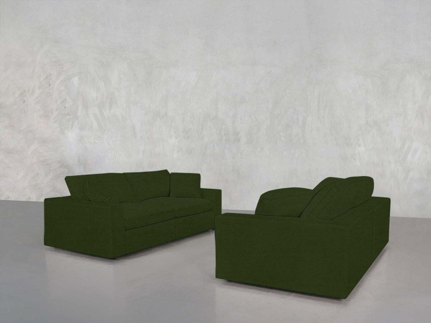 The 2-2 Sofa Set, in dark green, is arranged facing each other in a minimalist room with light gray walls and a smooth gray floor, creating a simple and uncluttered setting.