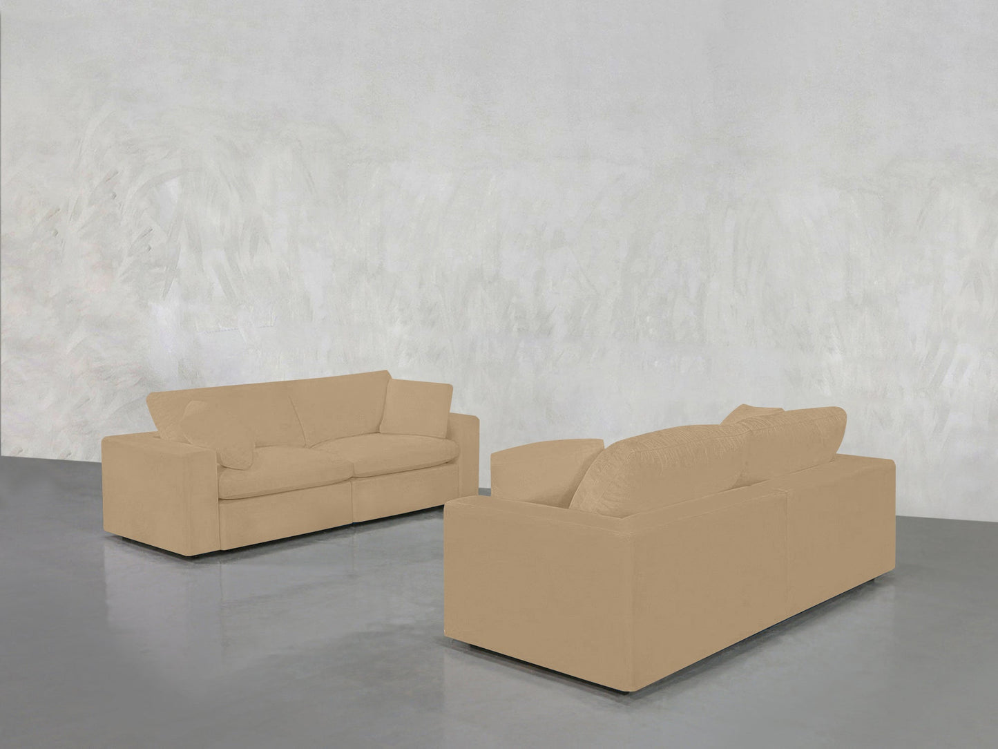 The 2-2 Sofa Set, in beige, is arranged in a minimalist room with a light gray textured wall and glossy gray floor. One sofa faces forward, the other faces away.