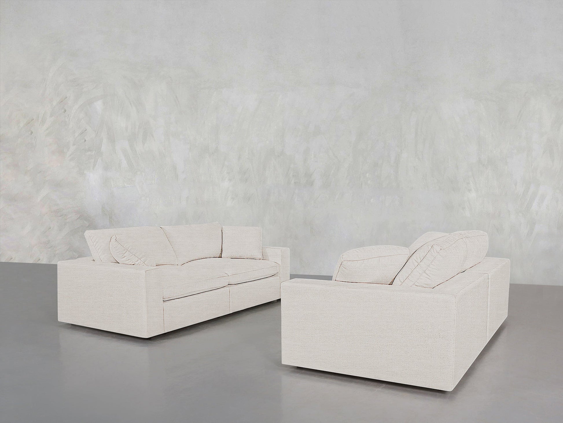 The 2-2 Sofa Set features two modern, light beige sofas with clean lines, placed on a polished gray floor against a textured, light wall for a minimalist and contemporary look.
