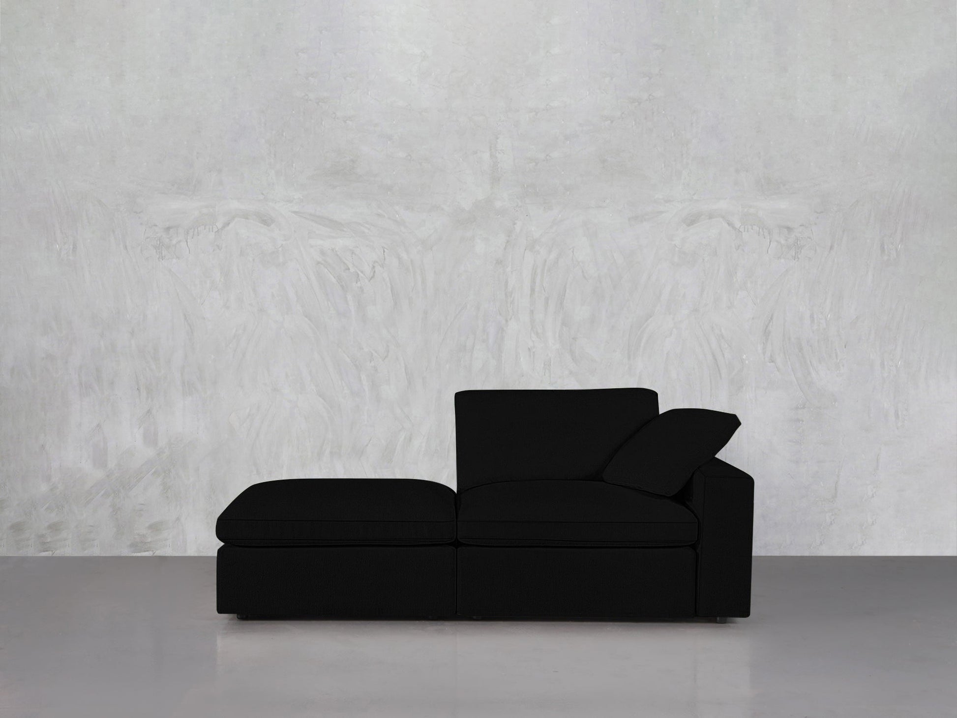 A 2-Seat Modular Lounger Loveseat is placed against a light gray textured wall, resting on a glossy light gray floor.