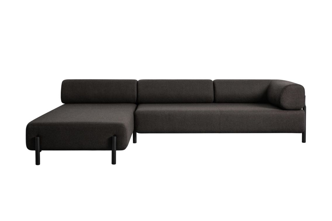 The Palo 3-seater Sofa is a minimalist, dark gray L-shaped piece with a low backrest that boasts a modern design. Its sleek and contemporary look is enhanced by rounded edges and black cylindrical legs.
