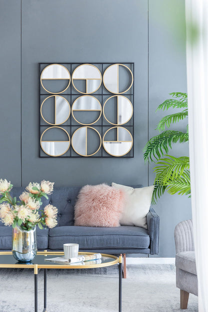 Modern living room with a gray sofa, pink and white pillows, a coffee table with flowers and cups, a potted plant, soft natural light from a window, and an Eclectic Styling Metal Beaded Wall Mirror with contemporary design.