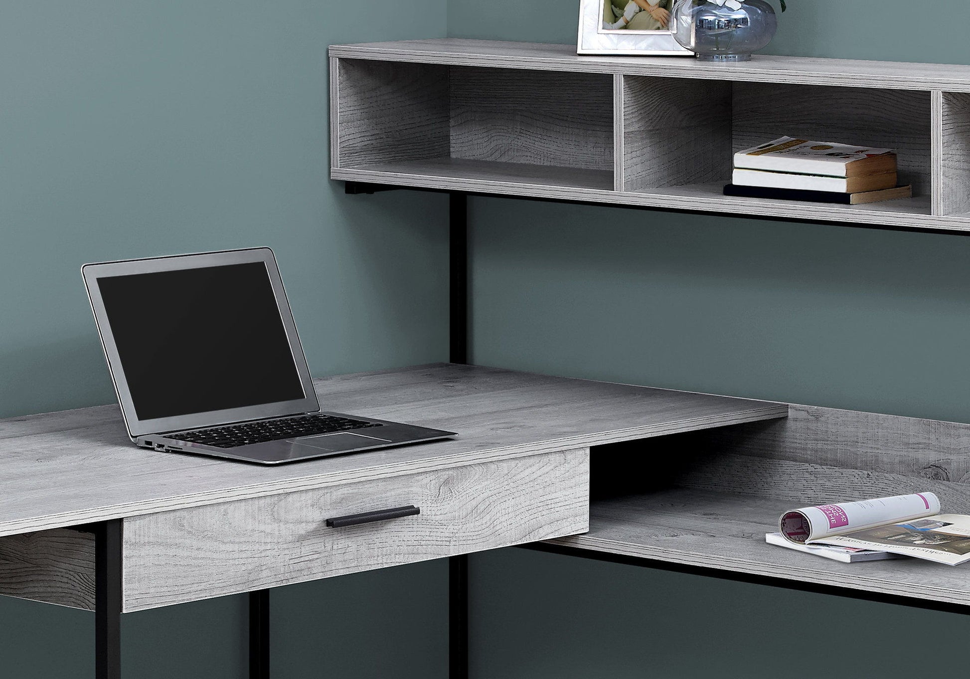 The contemporary L-shaped Computer Desk features storage drawers and open shelves for a laptop, book, and décor, complementing any home office with its modern design.