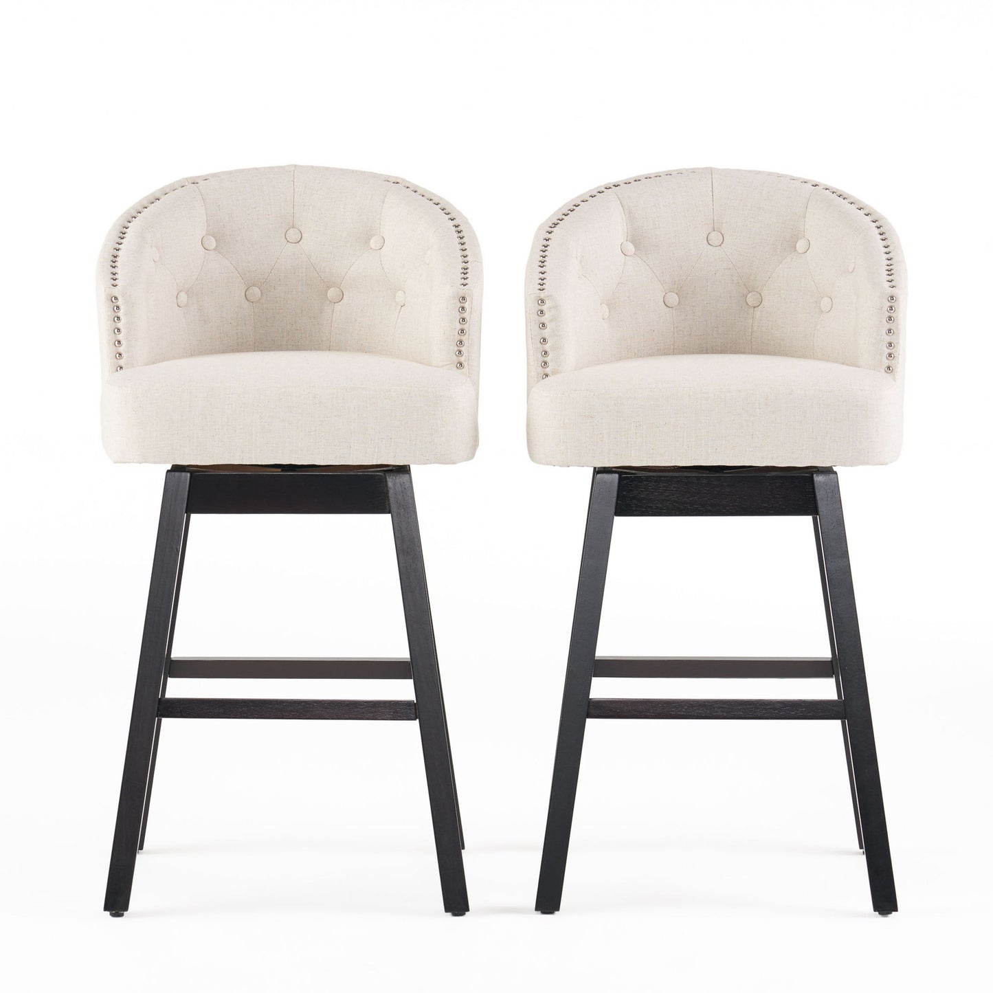 Two Mellifluous 360 Degree Swivel Bar Stools with stunning nailhead trim, tufted beige upholstery, rounded backs, and dark wooden legs are placed side by side against a white background.