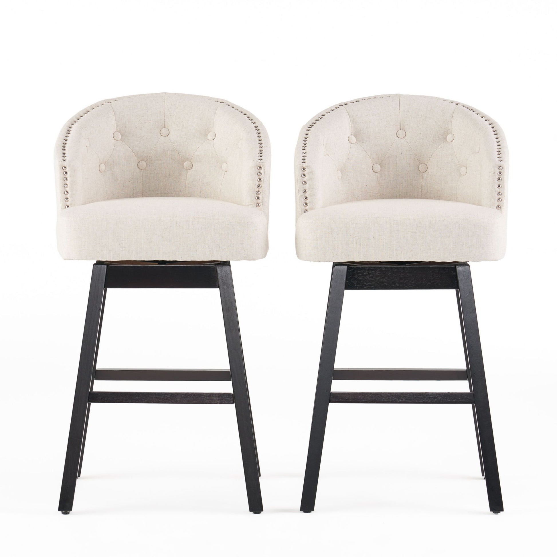 Two Mellifluous 360 Degree Swivel Bar Stools with stunning nailhead trim, tufted beige upholstery, rounded backs, and dark wooden legs are placed side by side against a white background.