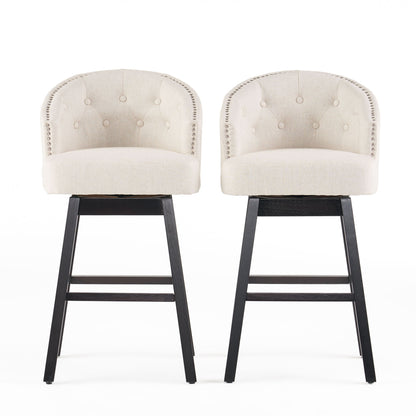 Two Mellifluous 360 Degree Swivel Bar Stools with stunning nailhead trim, tufted beige upholstery, rounded backs, and dark wooden legs are placed side by side against a white background.