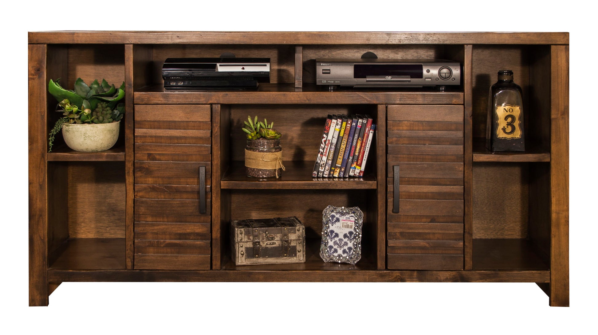The Sausalito TV Stand Console holds plants, electronics, a vintage bottle, DVDs, and decor on open shelves. Its center features two louvered cabinet doors plus open shelving for extra storage and display.