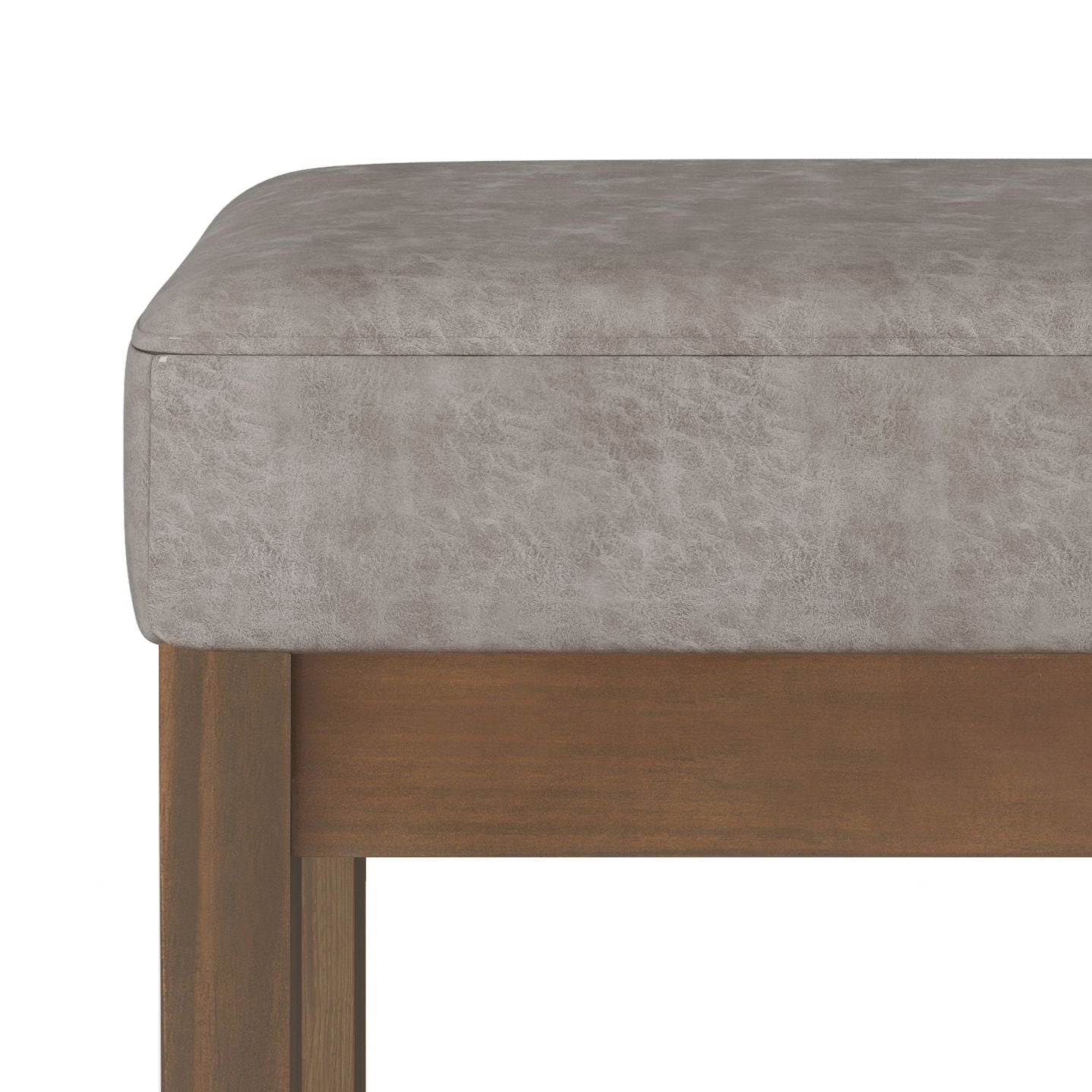 Close-up of the Milltown - Upholstered Ottoman Bench featuring a light grey faux-leather cushioned seat and brown-finished wooden legs, displayed against a white background.