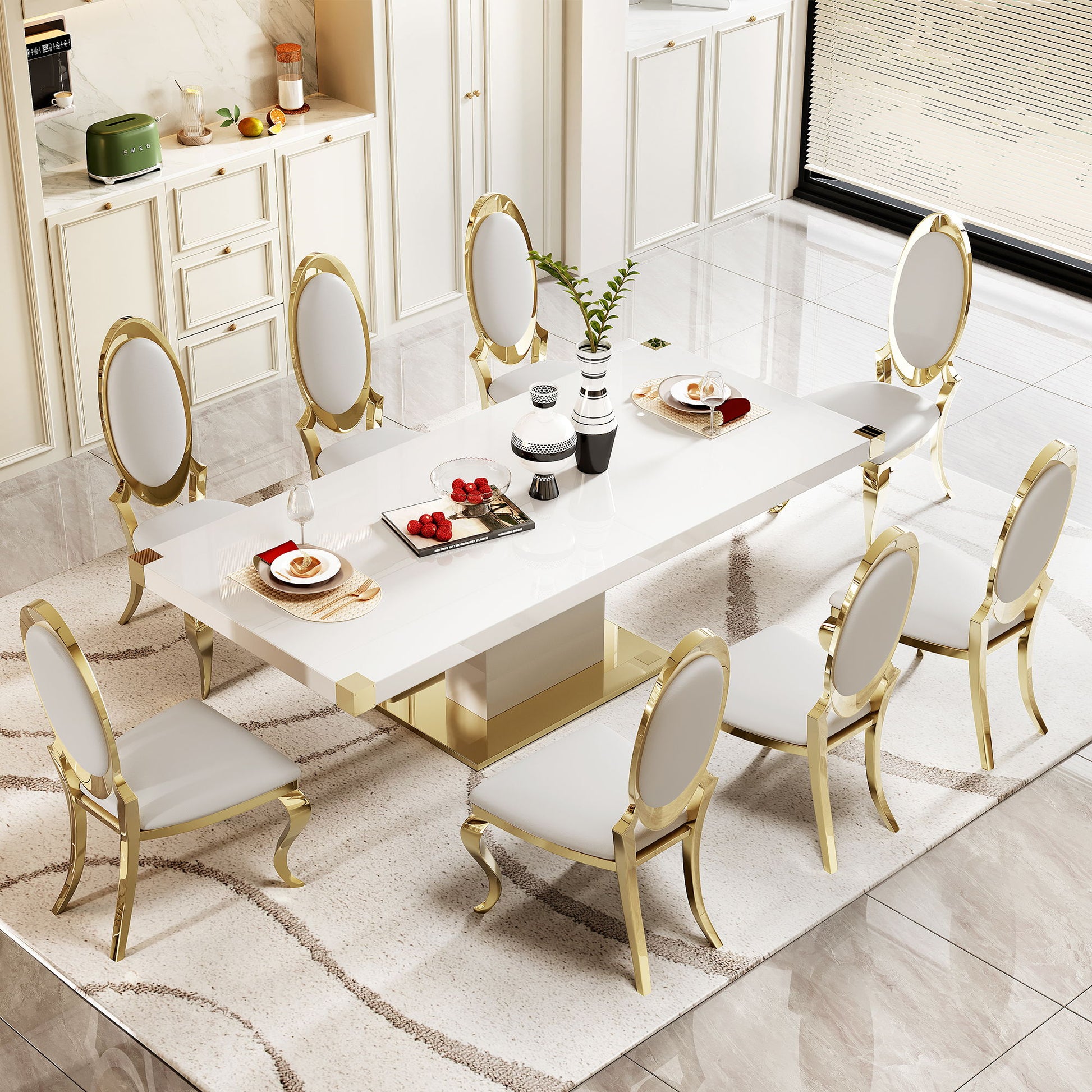An elegant dining room features the Top Dining Table With Finish Corner, white and gold, surrounded by eight white padded chairs with gold frames on a large white rug. The table is set with plates, fruit, and decor.