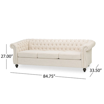 The Chesterfield Style 3 Seater Sofa With Deep Button Tufting features a cream color, rolled arms, and dark short legs. Dimensions: 27" H x 84.75" W x 33.5" D.