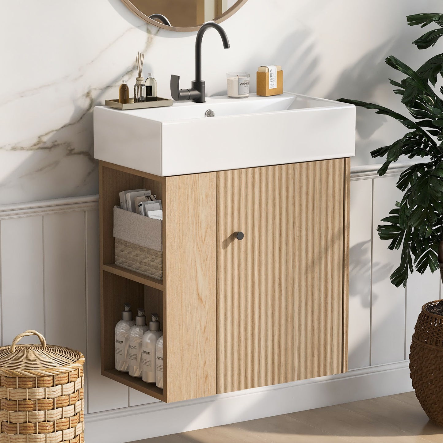 The Modern Floating Bathroom Vanity With Ceramic Basin features a white rectangular sink, light wood cabinet with vertical grooves, open shelves for toiletries, and suits small bathrooms. A round mirror and marble-detailed wall complete the look.