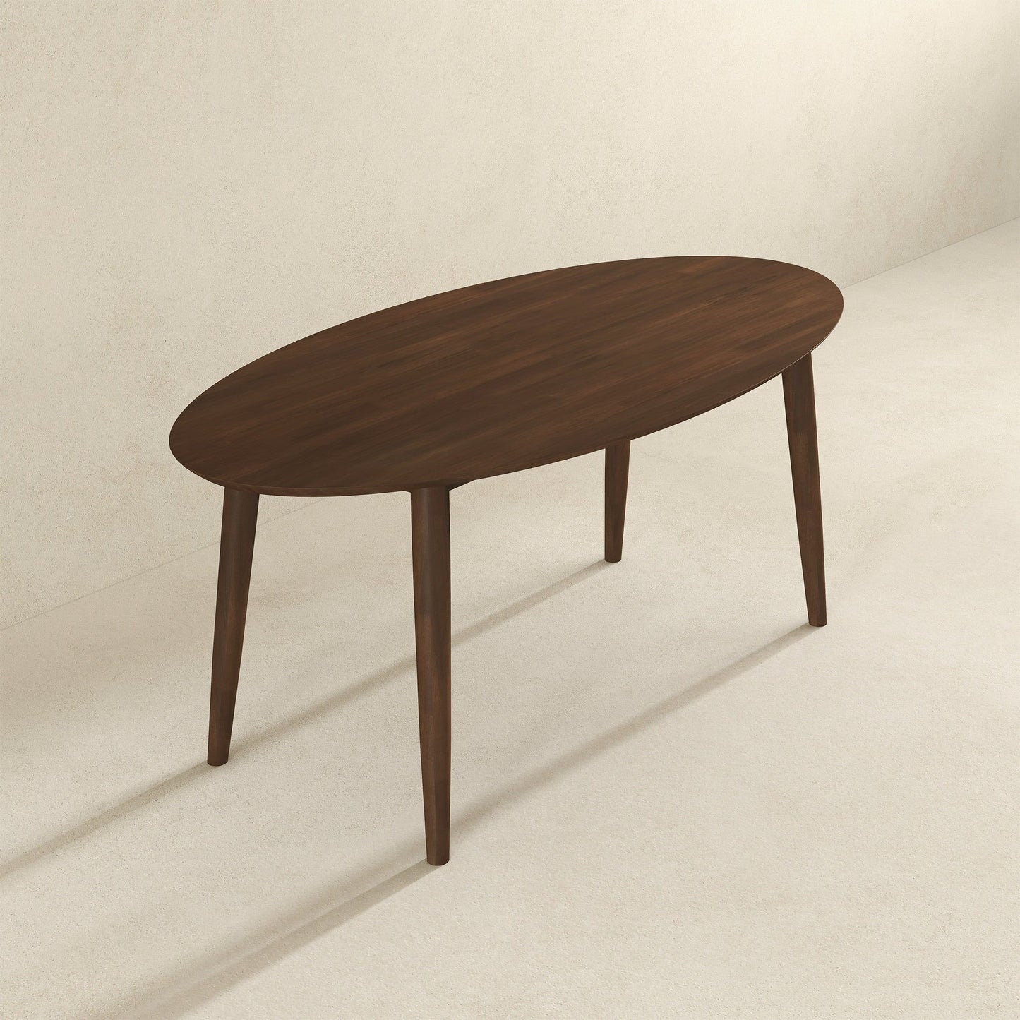 The Ada Mid-Century Modern Style Oval Dining Table, featuring a dark brown finish and four angled legs, stands on a light neutral floor against a plain wall.