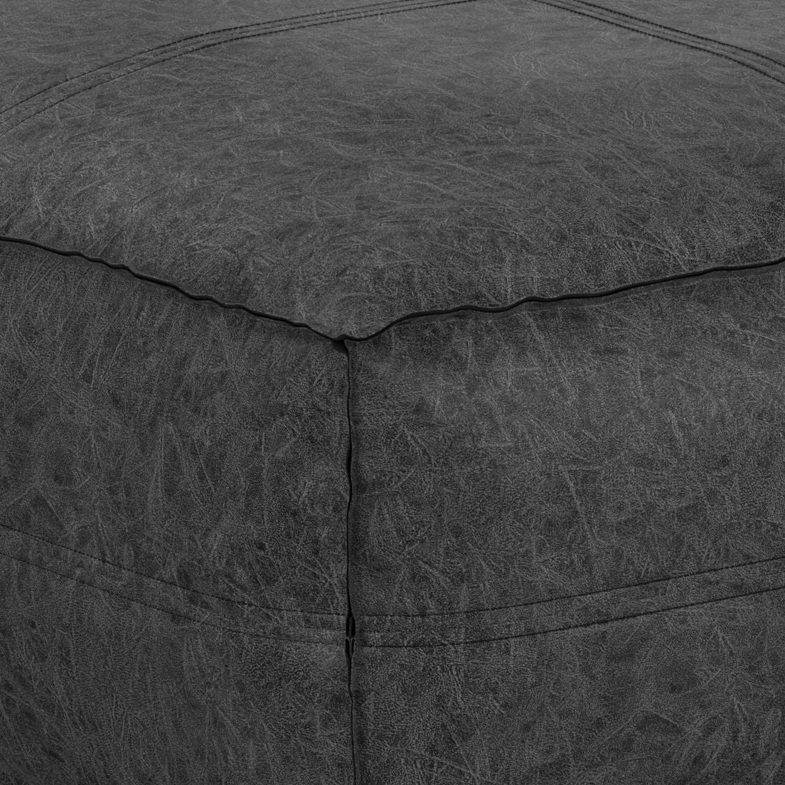 Close-up of the corner of the Brody Large Square Coffee Table Pouf in dark gray leather, highlighting its textured stitching and natural material creases.
