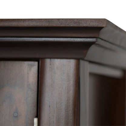 Close-up of the top corner of the Acadian Low Storage Cabinet in Brunette Brown, highlighting its detailed molding and smooth, polished dark wood finish against a white background.