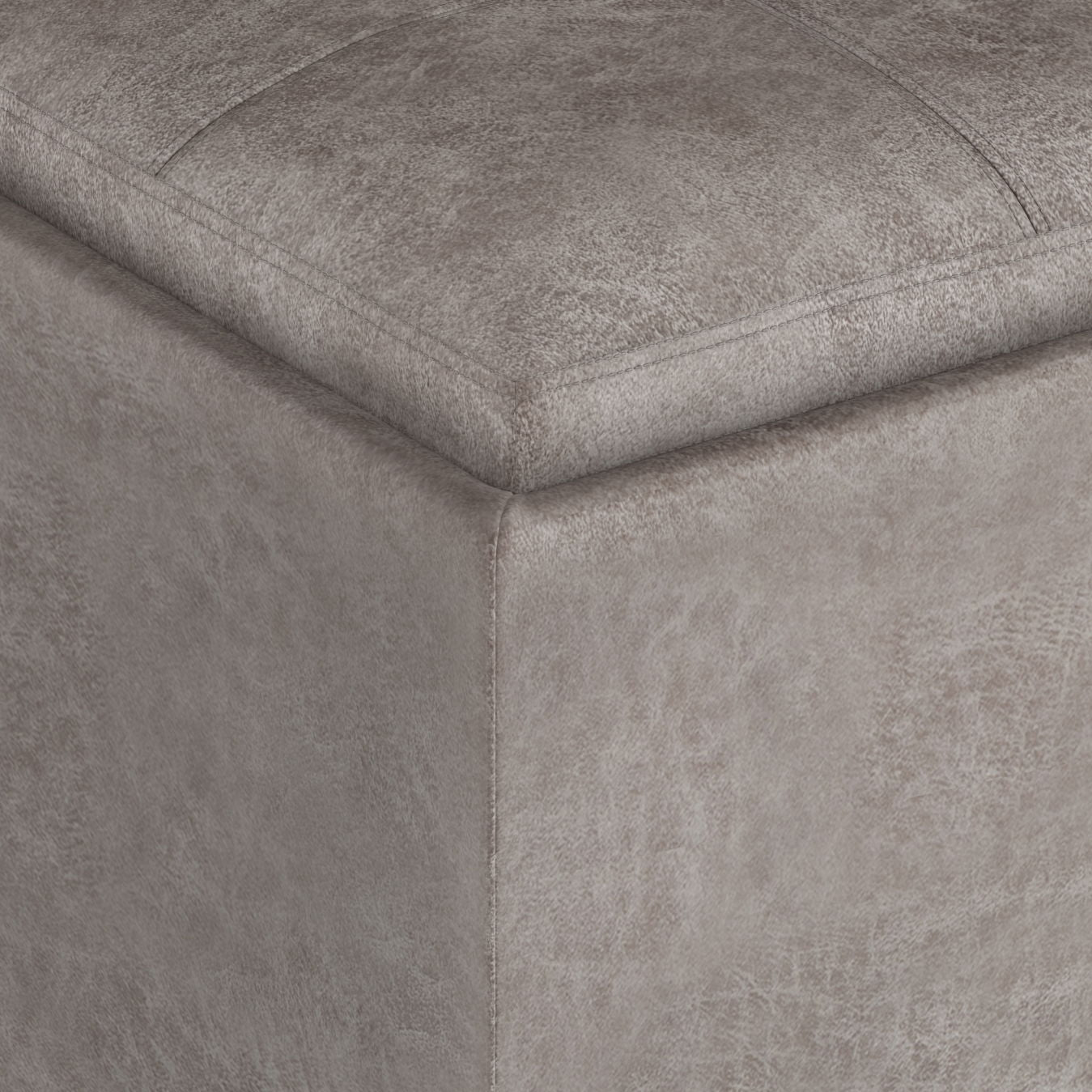 Close-up of the corner of the Rockwood Upholstered Cube Storage Ottoman With Tray, highlighting stitched seams and textured gray fabric.