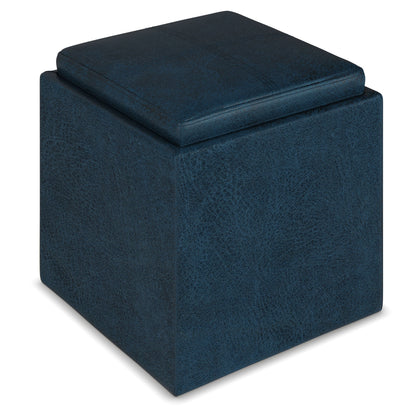 The Rockwood Upholstered Cube Storage Ottoman With Tray is a dark blue, cube-shaped ottoman with a cushioned top, shown against a white background.