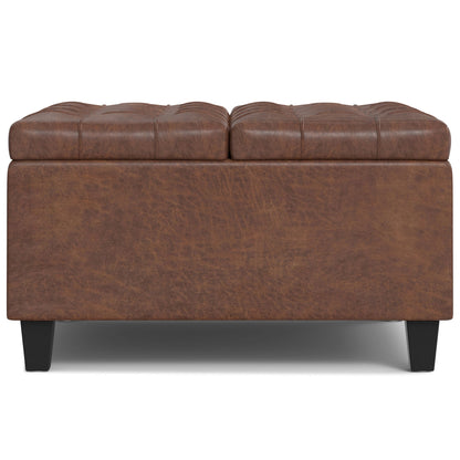 The Harrison - Large Coffee Table Storage Ottoman features brown leather, a tufted cushioned top, black legs, and a rectangular design, shown from the front on a white background.