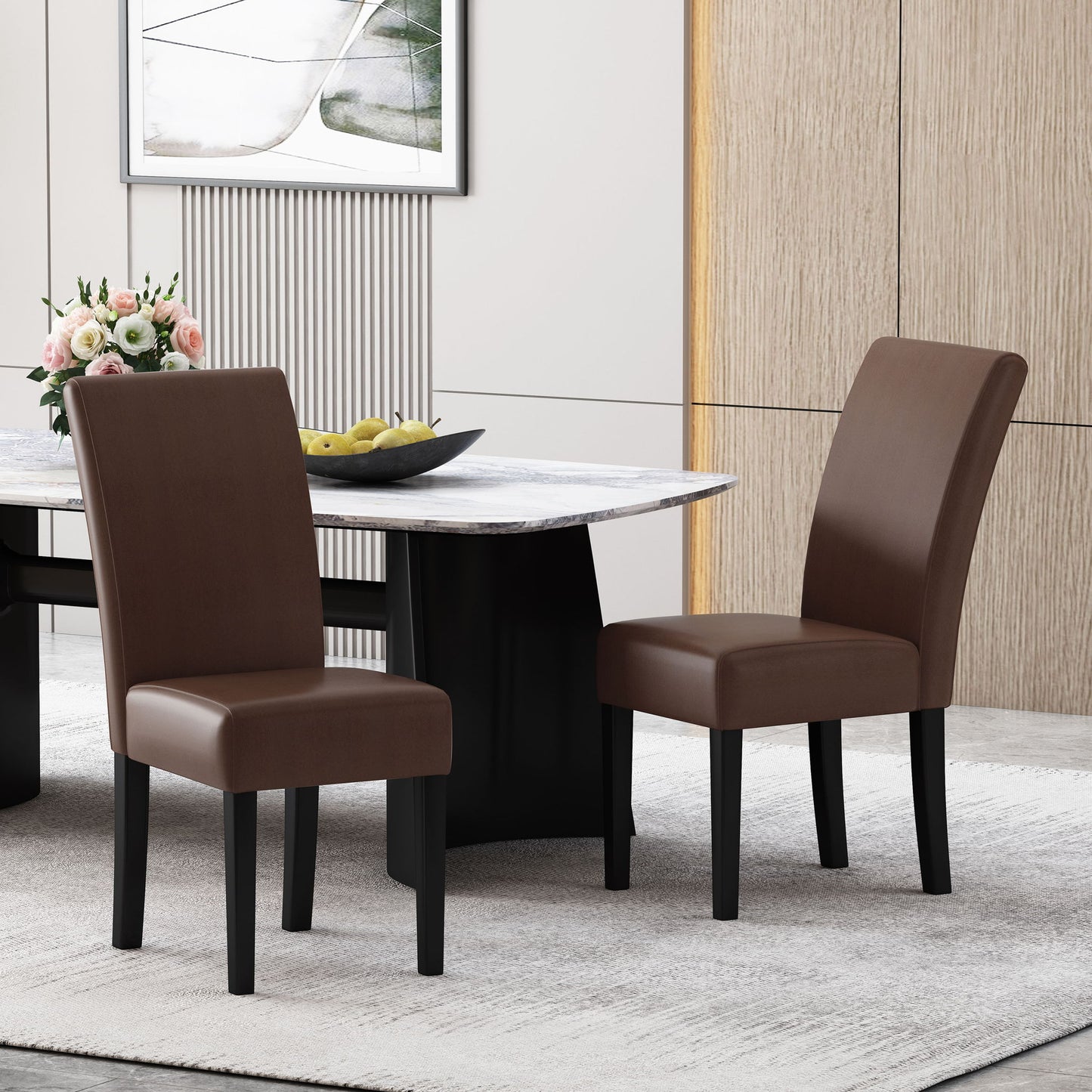 Two Contemporary Dining Chairs With Rubberwood Legs (set of 2) in brown upholstery are placed beside a marble-topped dining table. The table displays a black bowl filled with green apples and a floral vase, complementing the room’s neutral, minimalist decor.