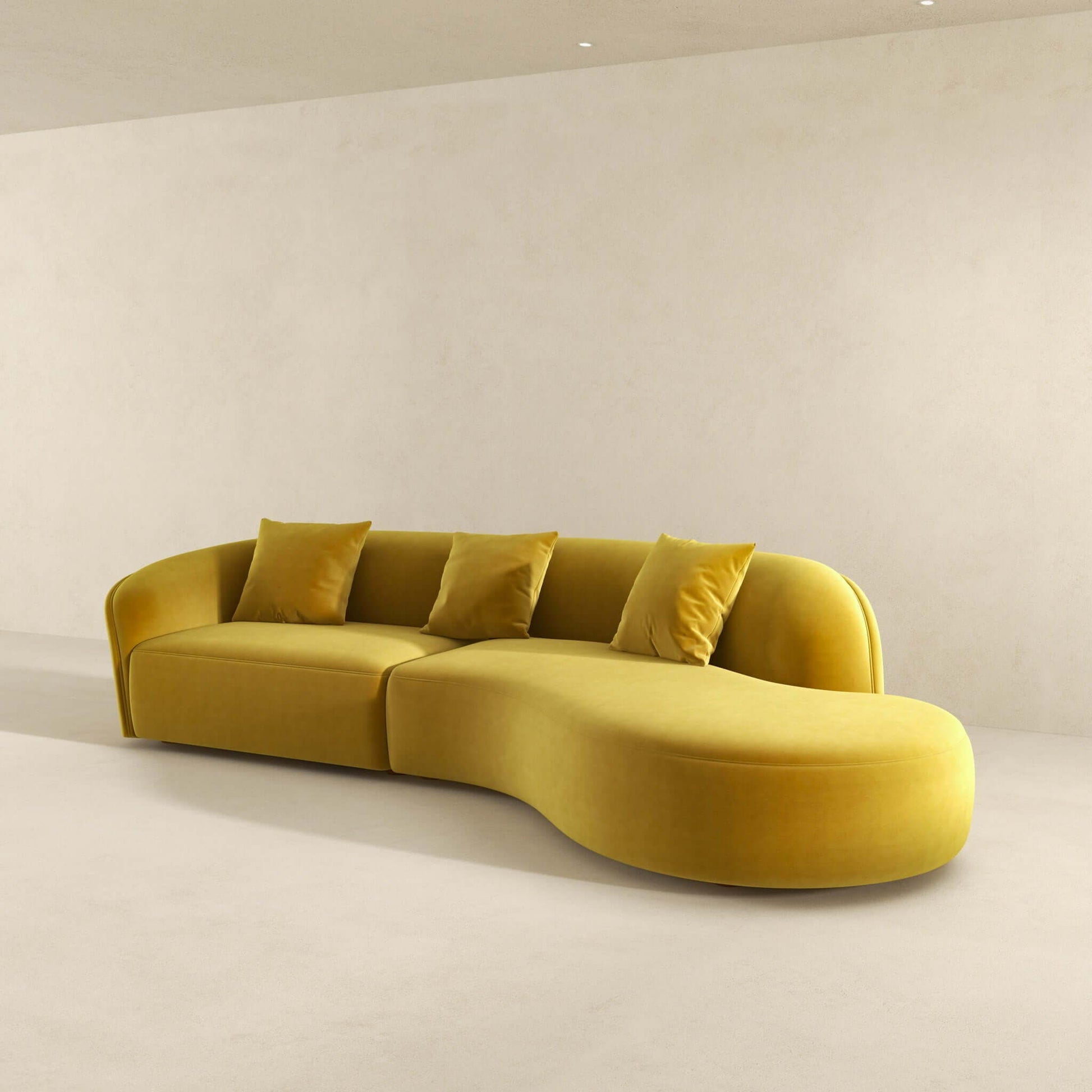 The Elijah Japandi Style Curvy Sectional Sofa in mustard yellow, featuring three matching cushions, adds a modern touch to a minimal room with neutral walls and flooring.