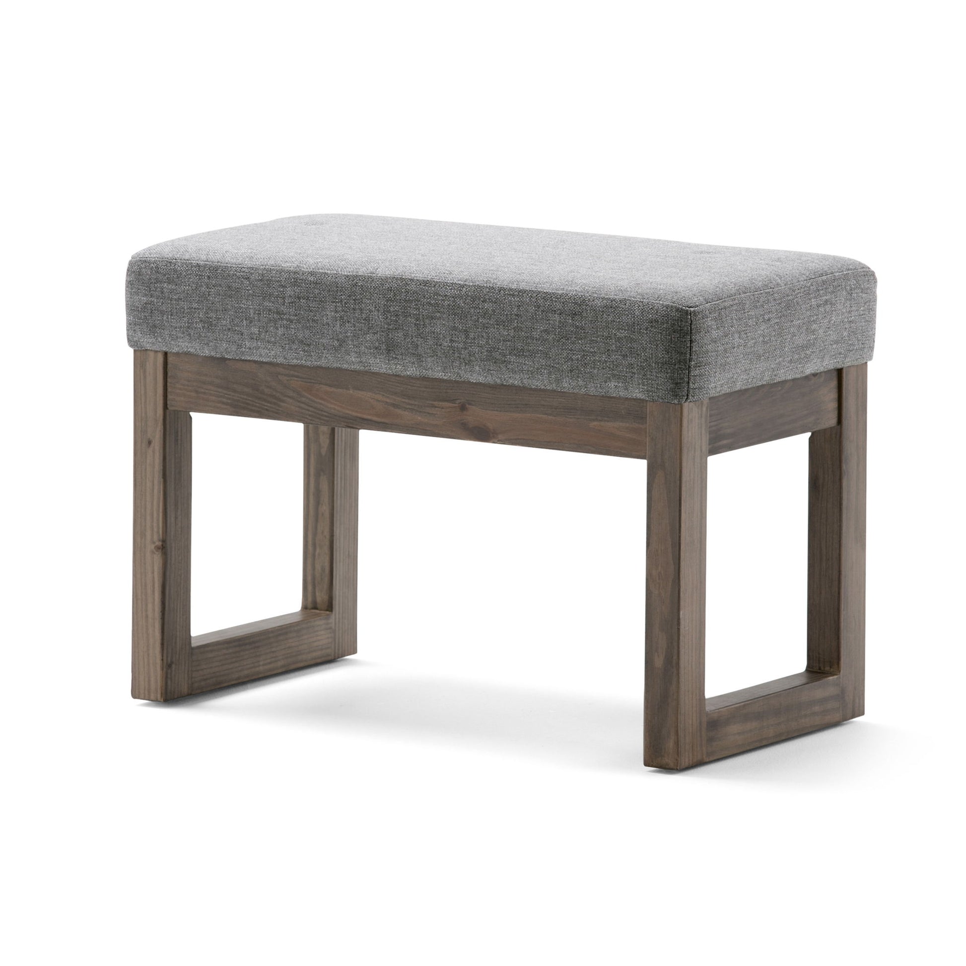 The Milltown Upholstered Ottoman Bench features a small, rectangular cushioned gray fabric seat and a simple wooden frame with square legs.