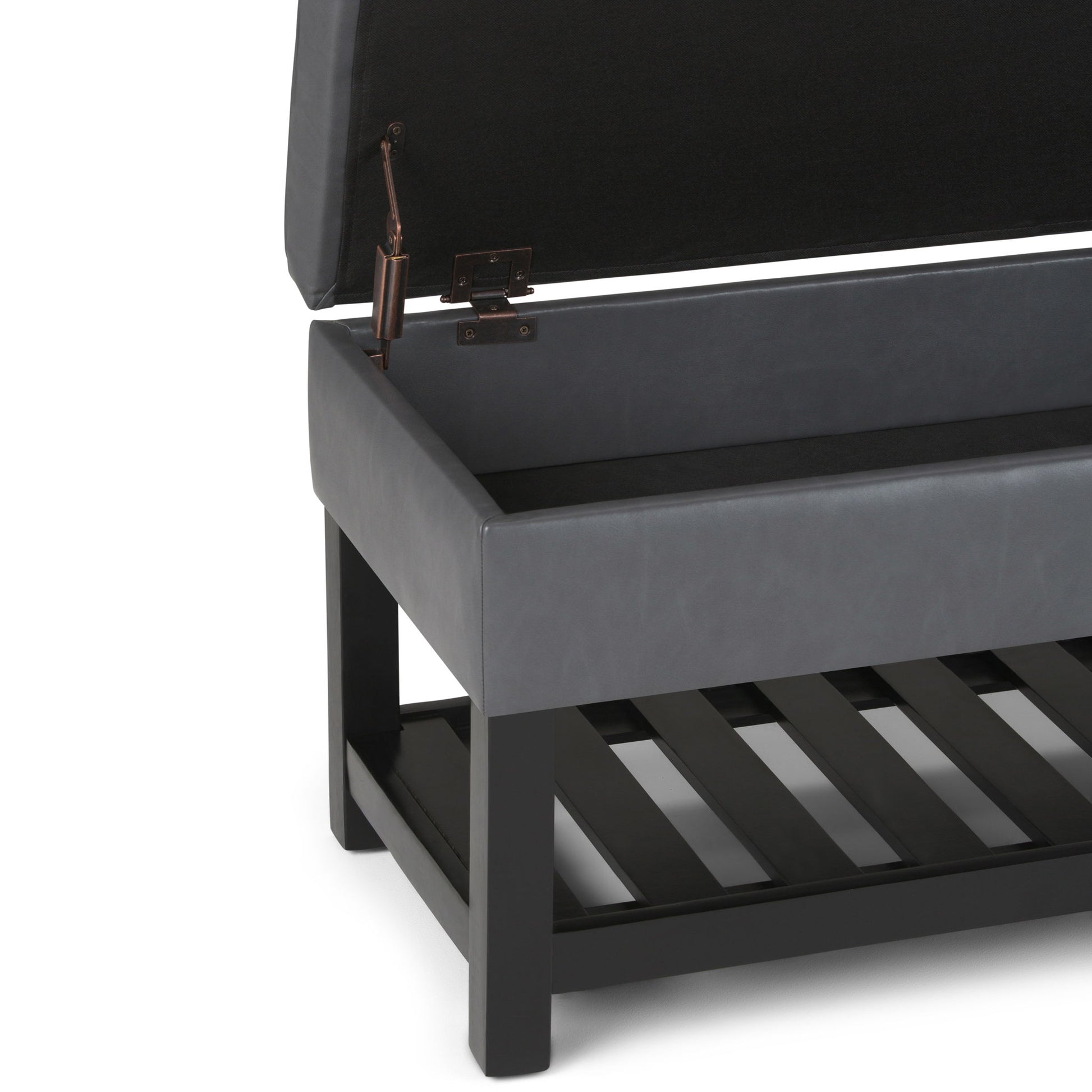 A close-up of the Cosmopolitan Storage Ottoman Bench With Open Bottom shows its black cushioned lid lifted open, revealing an empty storage compartment and a slatted shelf beneath, all supported by a dark wooden frame and legs.
