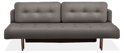 The Deco Convertible Sleeper Sofa is a contemporary gray piece with a minimalist design, boasting two back cushions and a flat seat, both adorned with button-tufted details. It features wooden legs and exudes a sleek and stylish look.