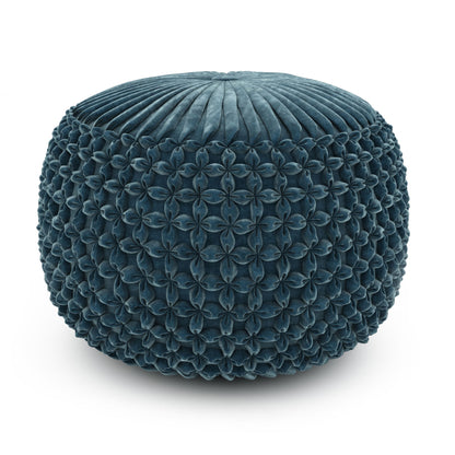 The Renee - Handcrafted Round Pouf is a round, teal ottoman featuring textured, petal-like sides and a pleated top, shown against a white background.