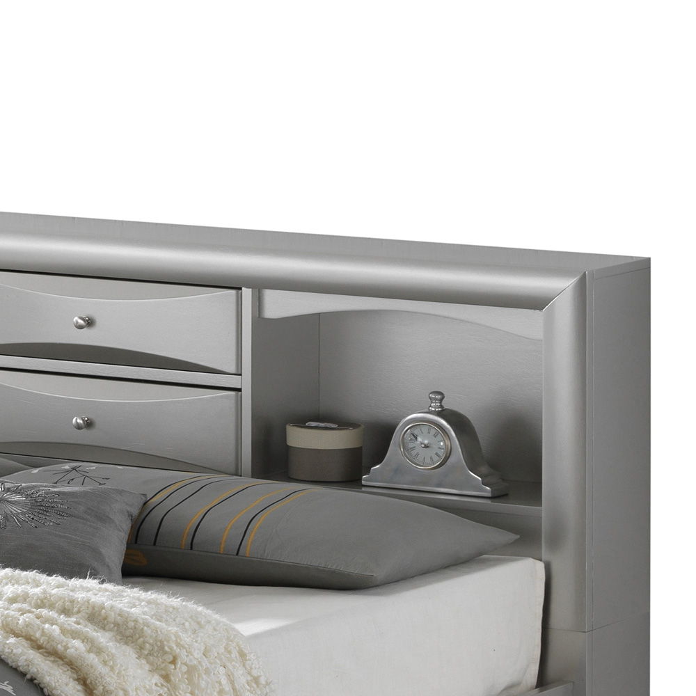 The Marilla Storage Bed with Bookcase Headboard features gray pillows and a white textured blanket, while its built-in shelves display a silver clock and a small box.