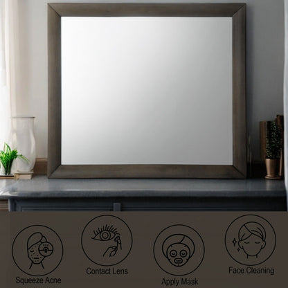 A large Ireland - Contemporary Design Mirror with a dark frame sits on a countertop. Below are four icons illustrating skincare steps: acne squeezing, contacts insertion, face mask application, and cleaning. The minimalist design includes light-colored walls.