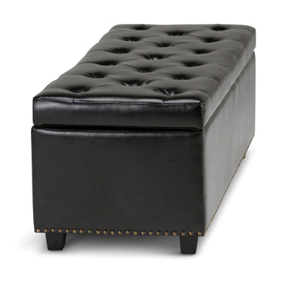 The Hamilton - Upholstered Storage Ottoman features black tufted leather, a rectangular shape, short legs, decorative nailhead trim along the base, and a cushioned top that lifts for storage.