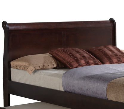 The Elegant Trundle Bed With Timeless Charm features a dark wooden sleigh-style headboard, beige and brown pillows, and neatly arranged gray and beige bedding.
