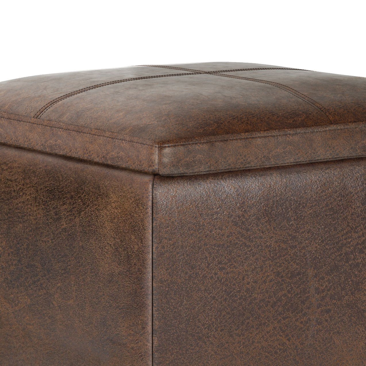 Close-up of the corner of the Rockwood - Upholstered Cube Storage Ottoman With Tray, featuring brown leather, visible stitching on the cushioned top, and a textured surface.