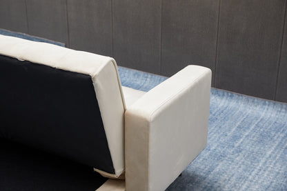 A close-up of the Comfort Compact Design Sofa Bed with white armrest and backrest, set on a blue gradient rug in front of a gray paneled wall.