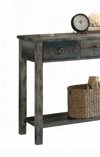 The Glancio Gray Console Table features two drawers, a decorative clock and coral ornament on top, plus a woven basket with books on its lower shelf.