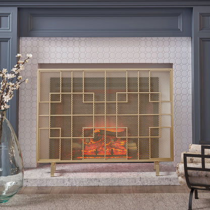 The Dorothy - Modern Single Panel Iron Fire Screen stands before a white hexagonal tile wall with gray paneling. To the left sits a large glass vase of white flowers; to the right, a striped chair completes the modern look.