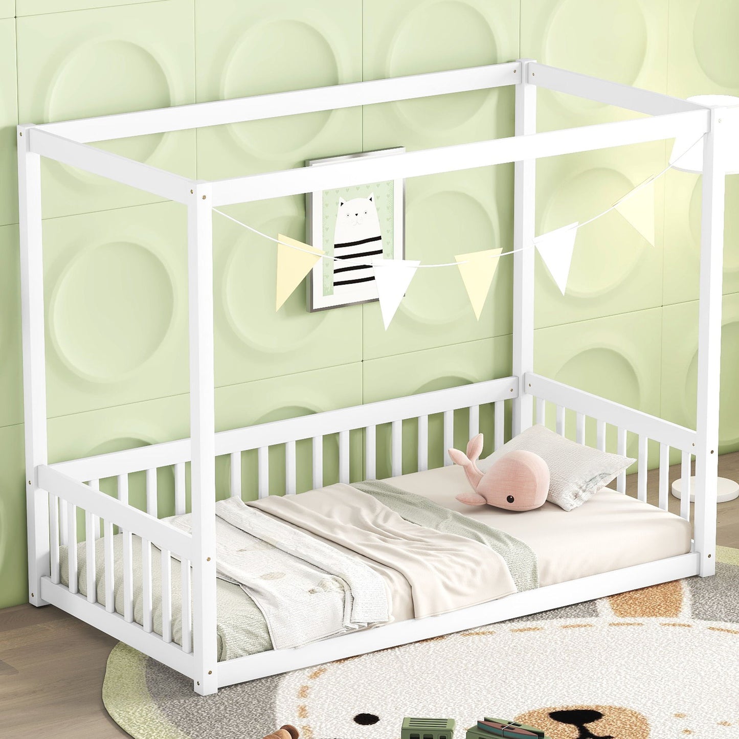 A Canopy Frame Floor Bed With Fence, Guardrails featuring a white frame and canopy is placed against a light green wall with a circular pattern. It’s adorned with triangular flags, pillows, a plush toy, blanket, and an animal picture above.