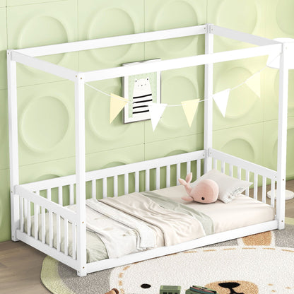 A Canopy Frame Floor Bed With Fence, Guardrails featuring a white frame and canopy is placed against a light green wall with a circular pattern. It’s adorned with triangular flags, pillows, a plush toy, blanket, and an animal picture above.