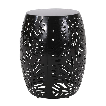 The Modern Design Metal End Table, Large, is a black drum-shaped table with perforated tropical leaf patterns in the metal, allowing light and air to flow through its stylish cutouts.