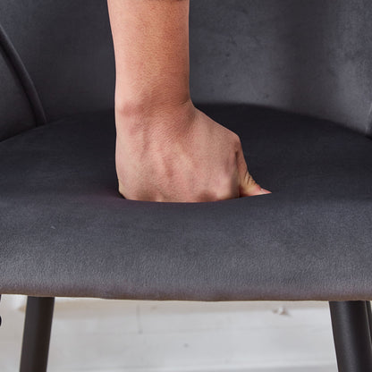 A hand presses down on the cushioned seat of the Counter Height Bar Stool Metal Legs (Set of 2) in dark gray, highlighting the softness and indentation of the fabric.